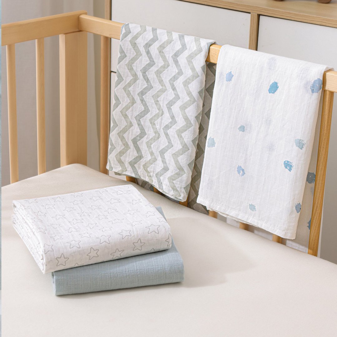 Chevron and star-print muslin blankets on a crib