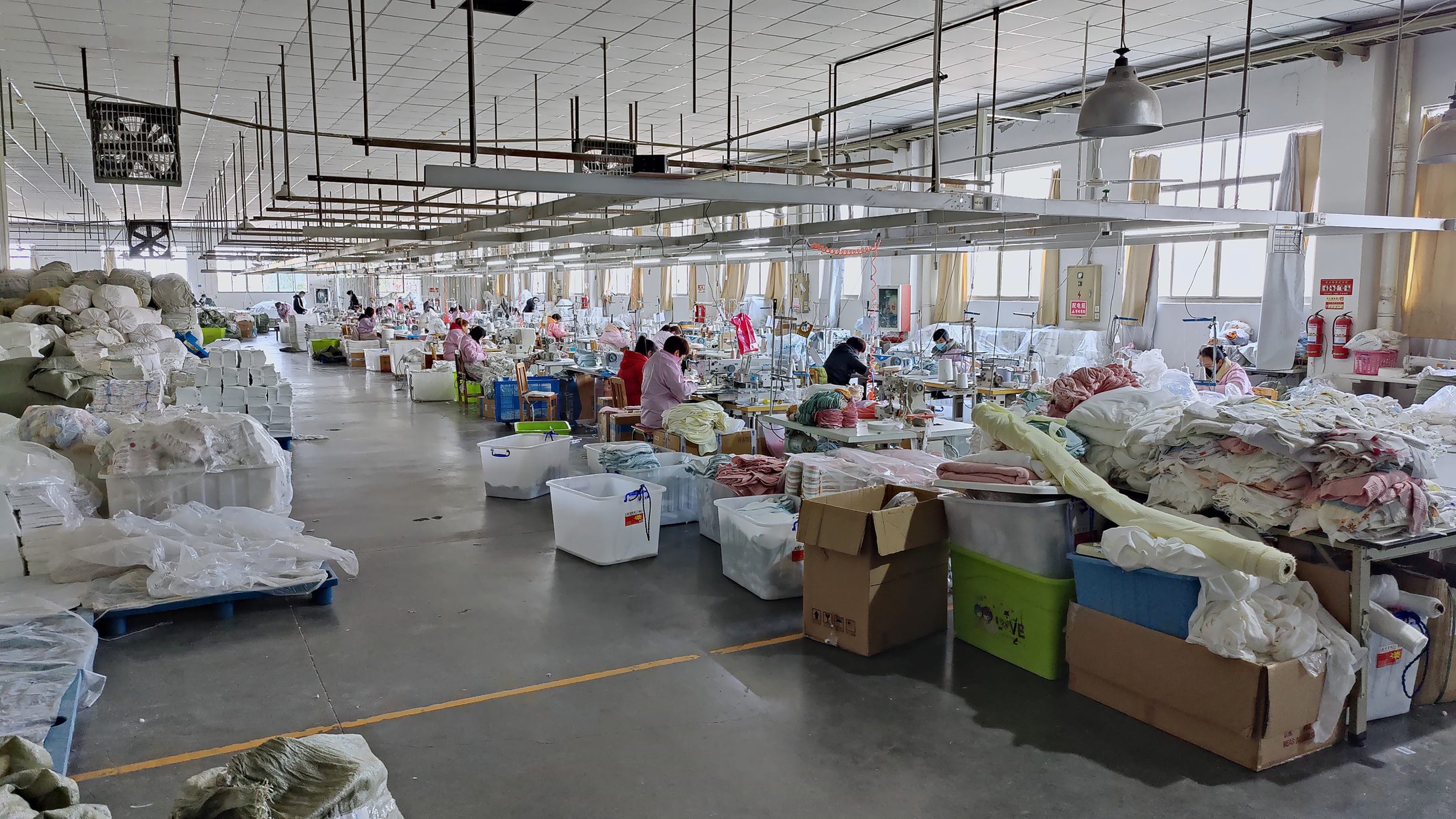 Sewing floor of our partner factory — greige fabric, cutting and sewing stations under one roof